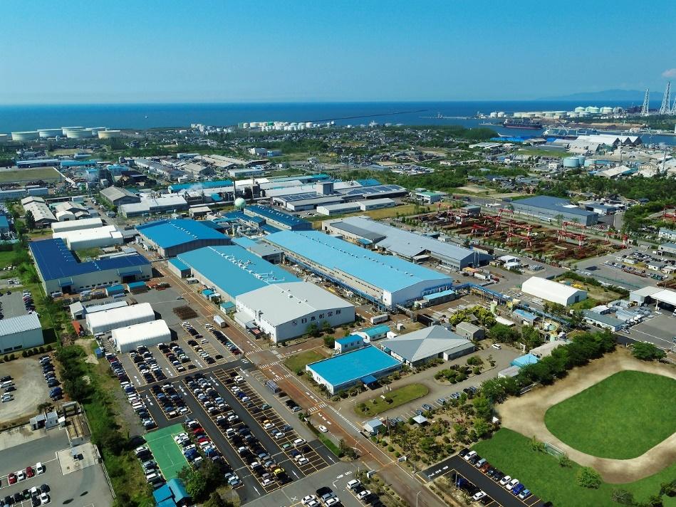 日軽金アクト株式会社の新潟工場は、新潟県新潟市北区にあります。同工場ではアルミニウムの大型押出形材や加工製品、ビール樽などの容器を製造しており、日本軽金属グループの主要な製造拠点の一つです。手前にはアルミニウムの押出や加工を行う広大な工場棟が並び、隣接する駐車場や緑地、遠方に広がる日本海までを一望できる。地域に根ざし、新幹線車体や自動車部品などの重要インフラを支えるものづくり拠点の全景を捉えている。